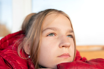Close up view portrait of young girl. She looking upwards wistfully and pensively full of plans and dreams