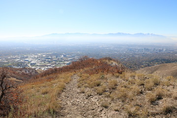 Fototapeta na wymiar Hiking trail in the foothills of the Wasatch Mountains late in the fall looking at the Salt Lake Valley in smog, Utah, USA