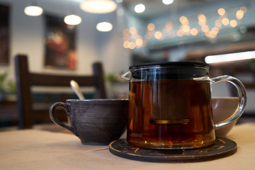 Cup and teapot on a table in a cafe.