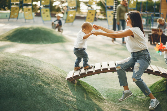 Family In A Park. Mother With Son. People On A Playground.