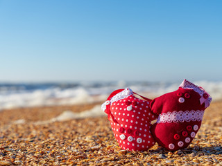 Image of soft toys in the form of mittens on the beach. Handwork.