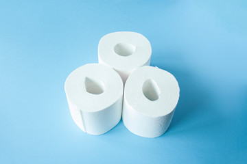 three Toilet paper roll on a blue background top view. Toilet paper purchase due to kronavirus concept. Personal hygiene and stopping the spread of the virus. Cleanliness, Hygiene, Sterility