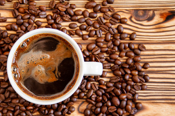White cup of coffee stands on coffee beans