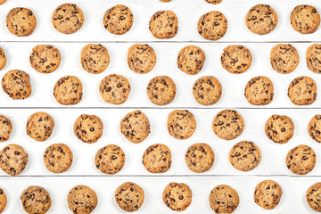 Round cookie with chocolate over the white wooden background, pattern of top view.