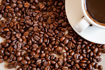 Roasted coffee beans with cup of coffee