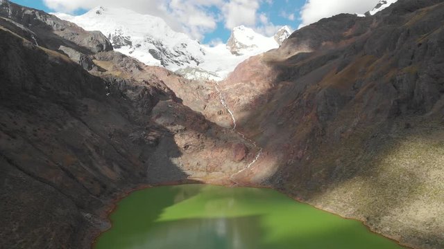 Shallap, the green lake in the peruvian andes, river and lake product of the defrosting glaciers, reverse shot, drone shot