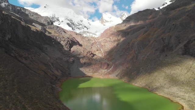 Shallap, the green lake in the peruvian andes, reverse flying over the lake, river product of the defrosting glaciers, amazing view.