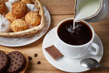 breakfast with croissants.Fresh crispy croissants and coffee with milk on a blue background and wooden table