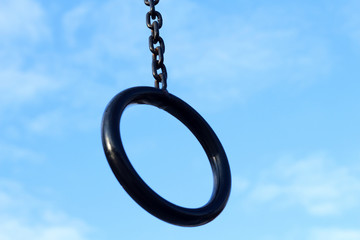 sporty black ring on a chain against a blue sky