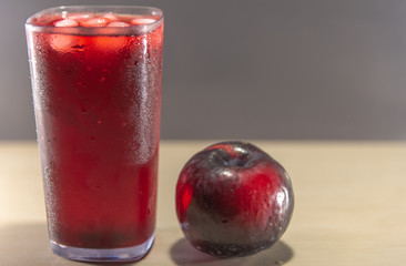 Plum juice and fruits (Prunus Alleghaniensis) on dark background