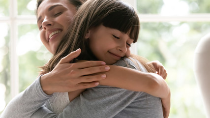 Cute little girl child embrace happy young mother show gratitude and love, caring happy smiling mom hug small preschooler daughter make peace reconcile after fight, family bonding, unity concept