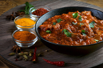 chicken curry with spices on a dark background