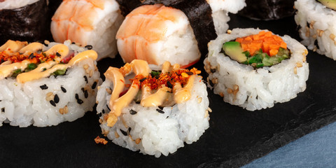 Sushi set panoramic close-up shot. An assortment of various maki, nigiri and rolls