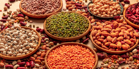 Legumes assortment on a brown background. Lentils, soybeans, chickpeas, red kidney beans, a vatiety of pulses