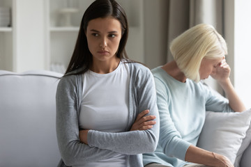 Offended millennial girl sit separately avoid talking with mature mother after fight, stubborn mad...