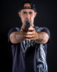 Fototapeta na wymiar man pointing gun at object, portrait on black background