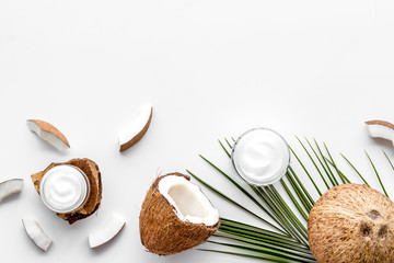 Skin care cream with coconut oil on white background top-down frame copy space