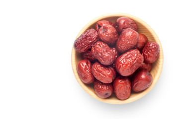 Dried red dates in a wooden bowl isolated on white background. Top view.