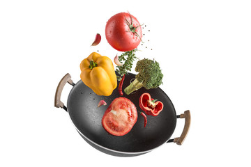 Fresh multicolored vegetables fly over a wok frying pan. White isolated background. - obrazy, fototapety, plakaty