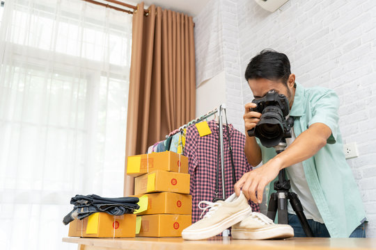 Asian man taking photo to shoes with digital camera for post to selling online on the internet, Start up small business owner e-commerce at home office