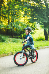 little boy riding on bicycle in helmet