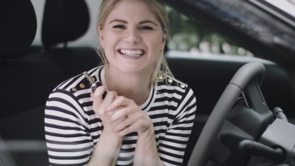 Excited young woman in new car