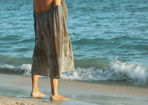 Grandfather changes clothes on the seashore.