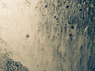 Auto glass in foam and water at a car wash as a backdrop