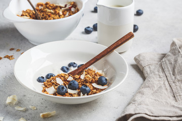 Granola with yogurt, coconut and berries in white plate. Healthy lifestyle concept.