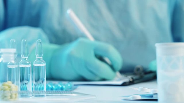 COVID-19 epidemic. Virus therapy. Doctor in protective gloves prescribing medication.