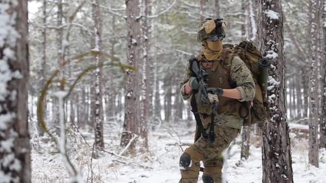 US Marine Corps makes his way through the snow forest.
