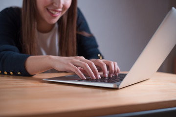 Unrecognizable woman using laptop, focus on her hands