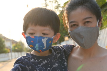 asian cute boy and woman mother wearing fabric mask in outdoor morning day protect your self from...