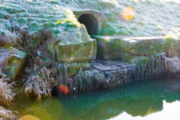 Odpływ ścieków kanał nad rzeką © Heroc