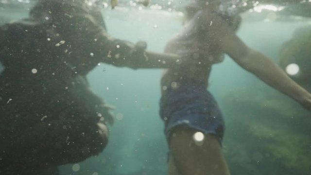 couple with cloths on moving underwater