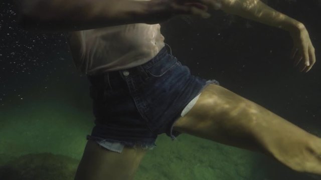 woman with cloths moving in slowmotion underwater