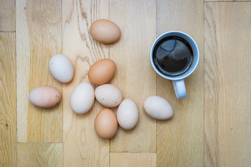 cup of coffee and eggs on wooden background