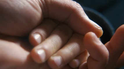 Friendly brothers`hands shaking and caressing each other inside of a room  