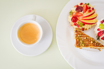 cup of tea with cake on white table
