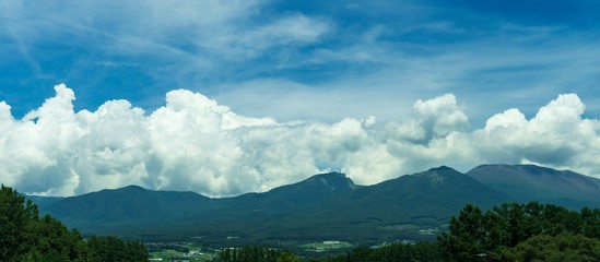 山並みに雲が沸き立つ夏の風景のパノラマ写真