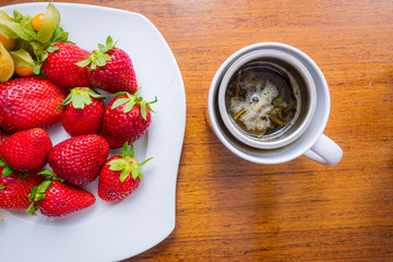 cup of tea with strawberries and on a wood table 