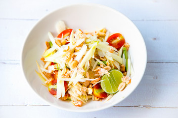 Somtum  in Thai with ingredients Papaya Salad, Thai food concept street food, Top view on wooden white background.