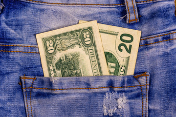American twenty dollar banknotes in a pocket of blue jeans