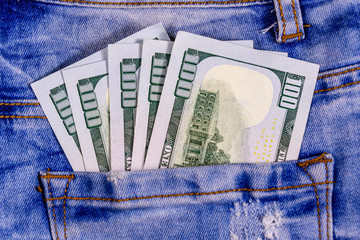American one hundred dollar banknotes in a pocket of blue jeans