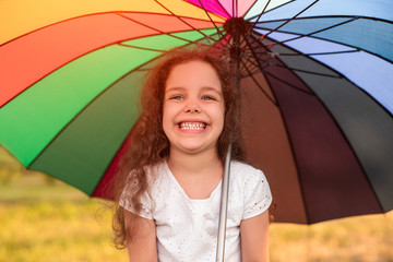 Cheerful little girl with colorful umbrella