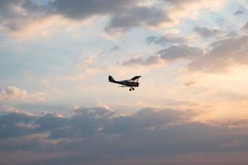 Fototapeta na wymiar biplane flying in the cloudy sky