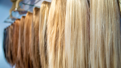 different colored and different types of wigs displayed in the shop