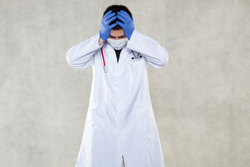 a doctor in protective clothing grabs his head