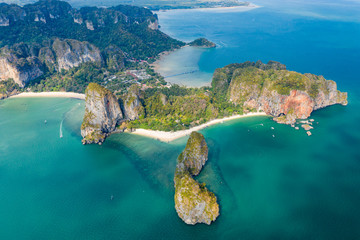 Aerial drone view of a beautiful tropical beach, towering cliffs and green jungle on an isolated...