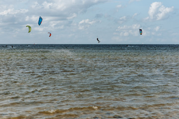 Kitesurfers are riding the waves of the Kieler Förde in the evening sun